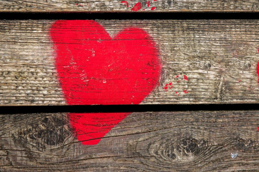 Red heart painted on a rustic wooden surface, symbolising love and emotional vulnerability during separation or divorce.