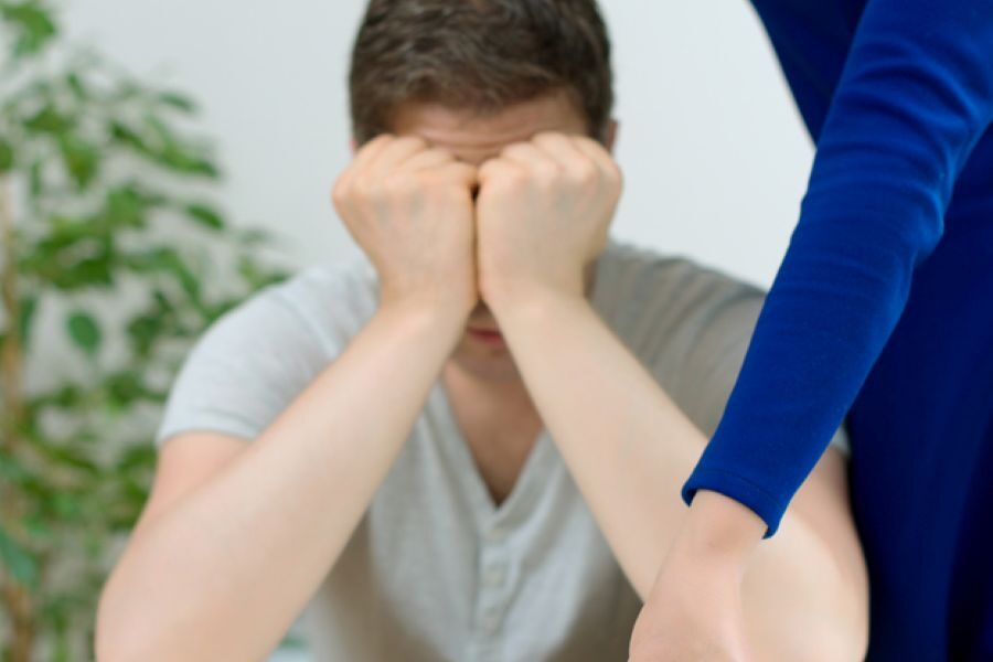 Man crying as woman hands back wedding ring during separation conversation