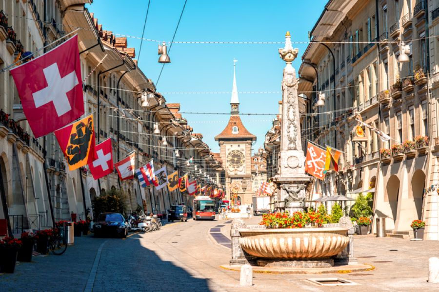 Street scene in Bern Old Town with historic buildings and Swiss flags