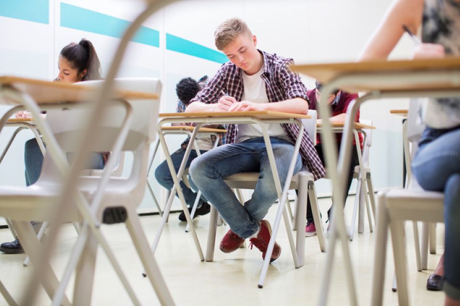 Student sitting GCSE exam in classroom while parents consider divorce timing in England and Wales